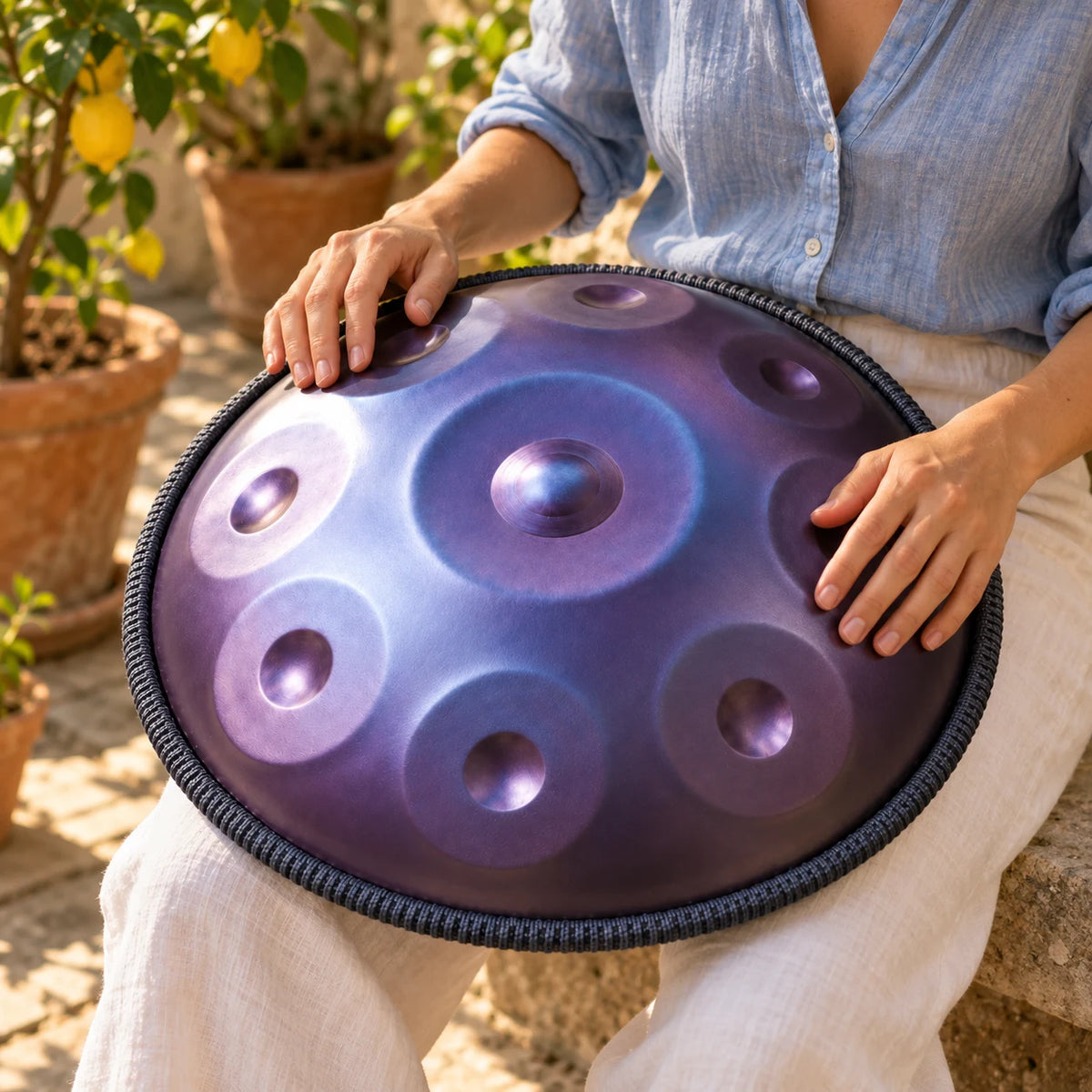 Handpan Risuono Essenziale viola mentre lo si suona in un cortile italiano