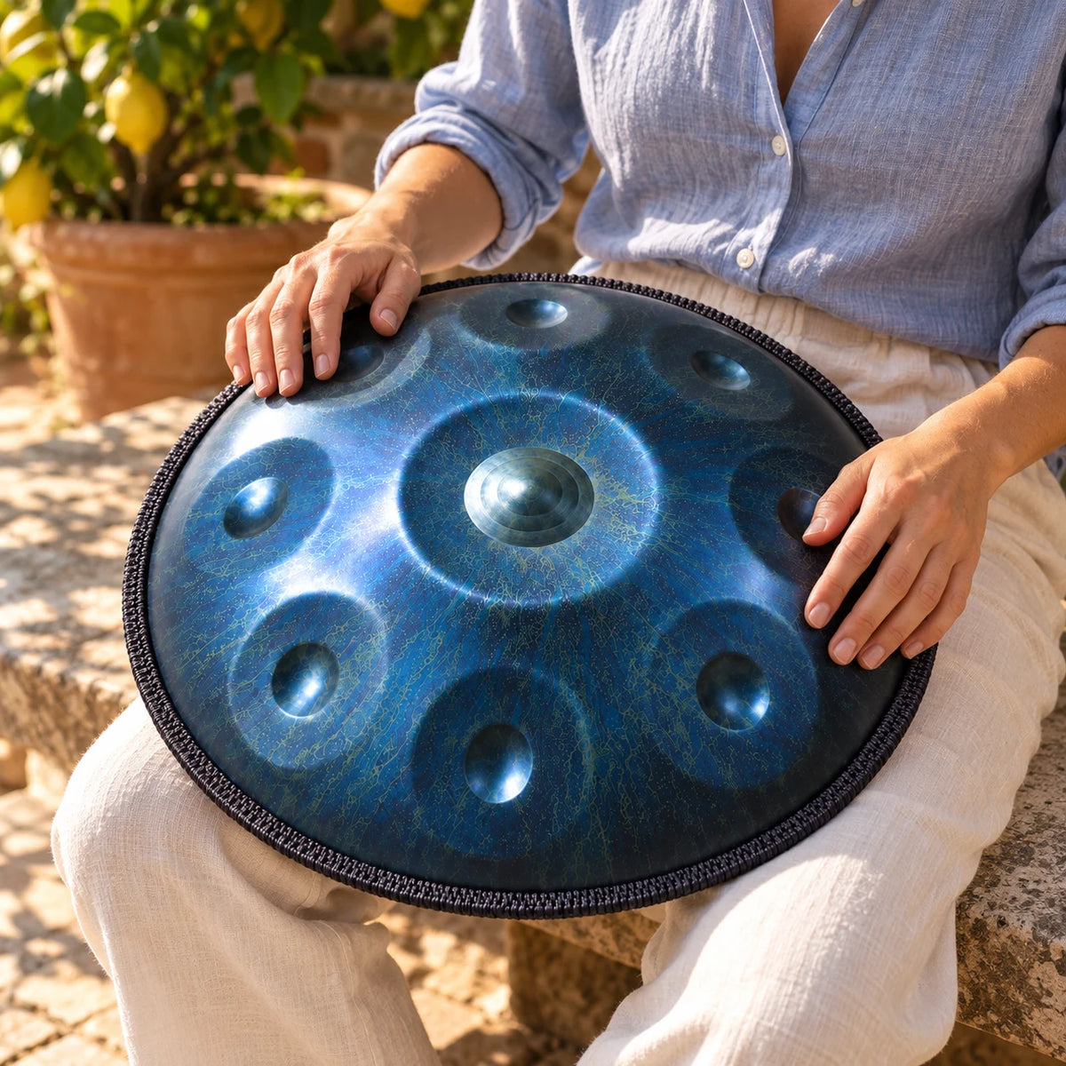 Handpan Risuono Stellare blu con motivo stellato mentre lo si suona in un cortile italiano