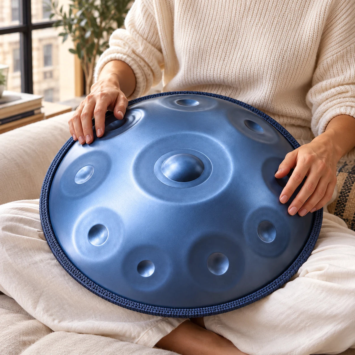 Handpan Risuono Glaciale azzurro mentre lo si suona in un appartamento a Milano