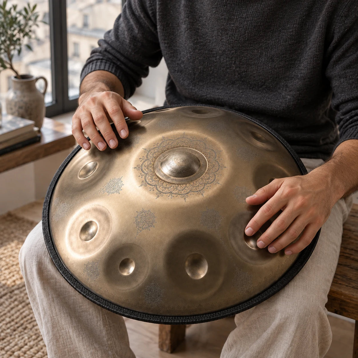 Handpan Risuono Ricamo dorato mentre lo si suona vicino a una finestra in un appartamento a Milano