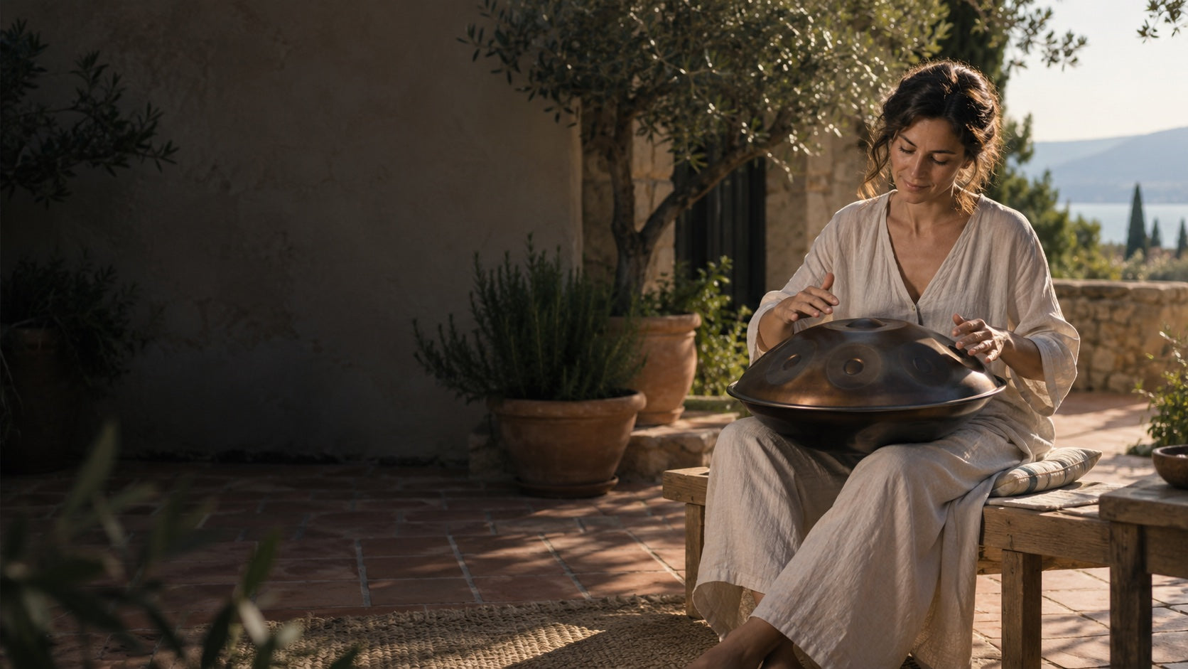 Una persona suona un handpan su una terrazza al sole